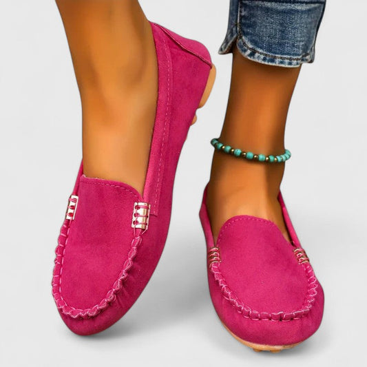 Women's hot pink suede slip-on loafers with white contrast stitching — front angled view